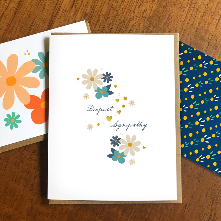 Sympathy card with sentiment 'Deepest Sympathy' featuring gold foil hearts and neutral color simple flowers in cream, dark teal and soft navy colors