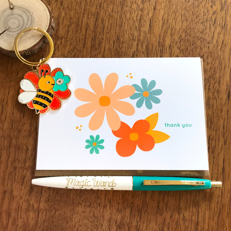 Thank you card with four modern flowers red, slate blue, aqua and peach with a click pen with saying 'Magic Wand' and a bumble bee smelling flowerskeychain.