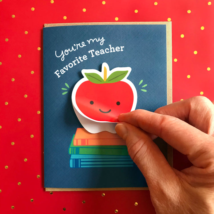 Greeting card for a teacher with hand showing how to use the removable sticker card. Red apple is a removable sticker.