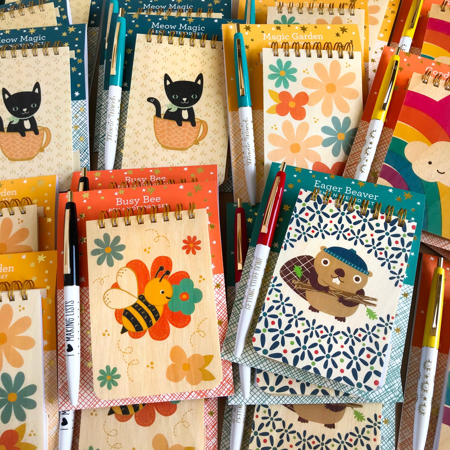Gift-ready packaged wood notepad and pen set with bright, flowers, black cat in cup, cute bee, happy beaver, fun rainbow and designed pens