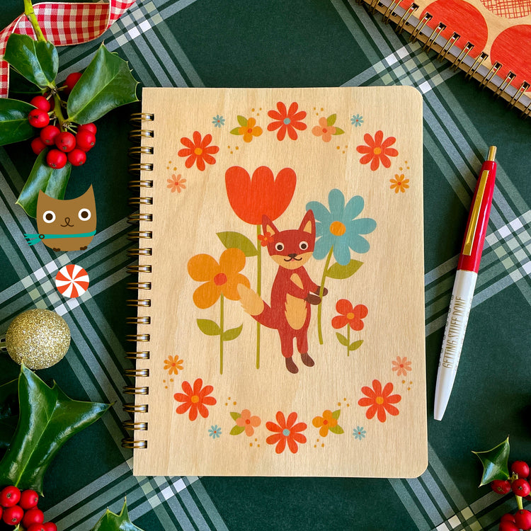 Real birch wood journal featuring cute fox standing holding a flower with a colorful modern flower border. Click pen with red cap with fun gold lettering that reads "Getting Stuff Done".