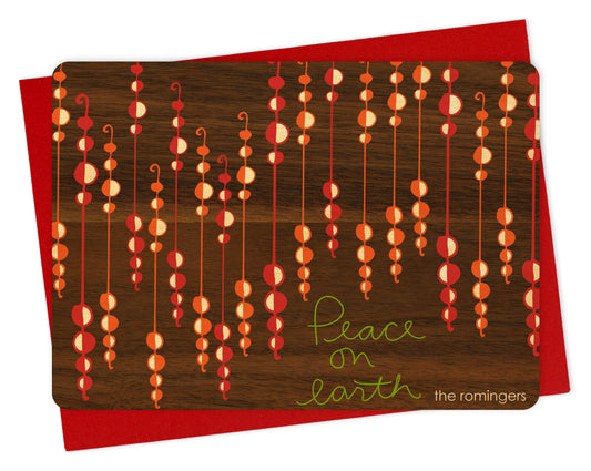 Customizable wood holiday card featuring festive beaded garlands with “Peace on Earth” text on a printed walnut wood grain background. Shown with a red envelope.