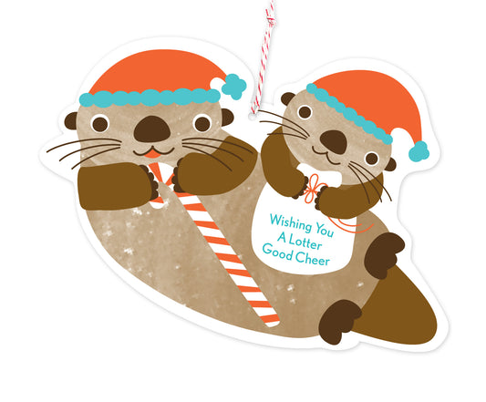 Front of die-cut paper holiday ornament card featuring two otters wearing Santa hats. One is holding a candy cane and the other is holding a bag with "Wishing You A Lotter Good Cheer" text.