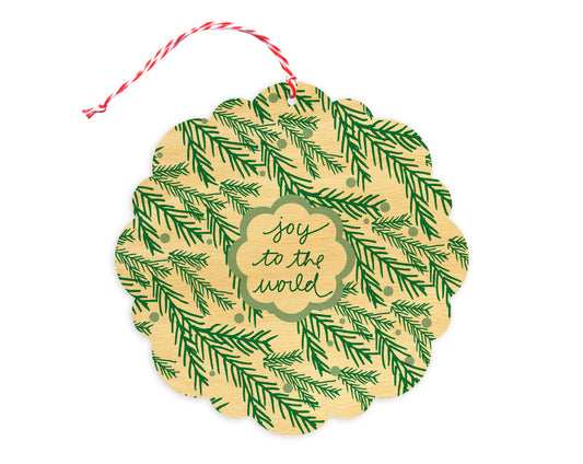 Front of customizable birch wood holiday ornament card with festive evergreen sprigs and "Joy to the World" text. Round ornament with scalloped edges.