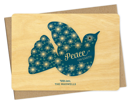 Customizable birch wood holiday card with blue dove, “Peace on Earth” sentiment and personal greeting. Shown with a kraft envelope.