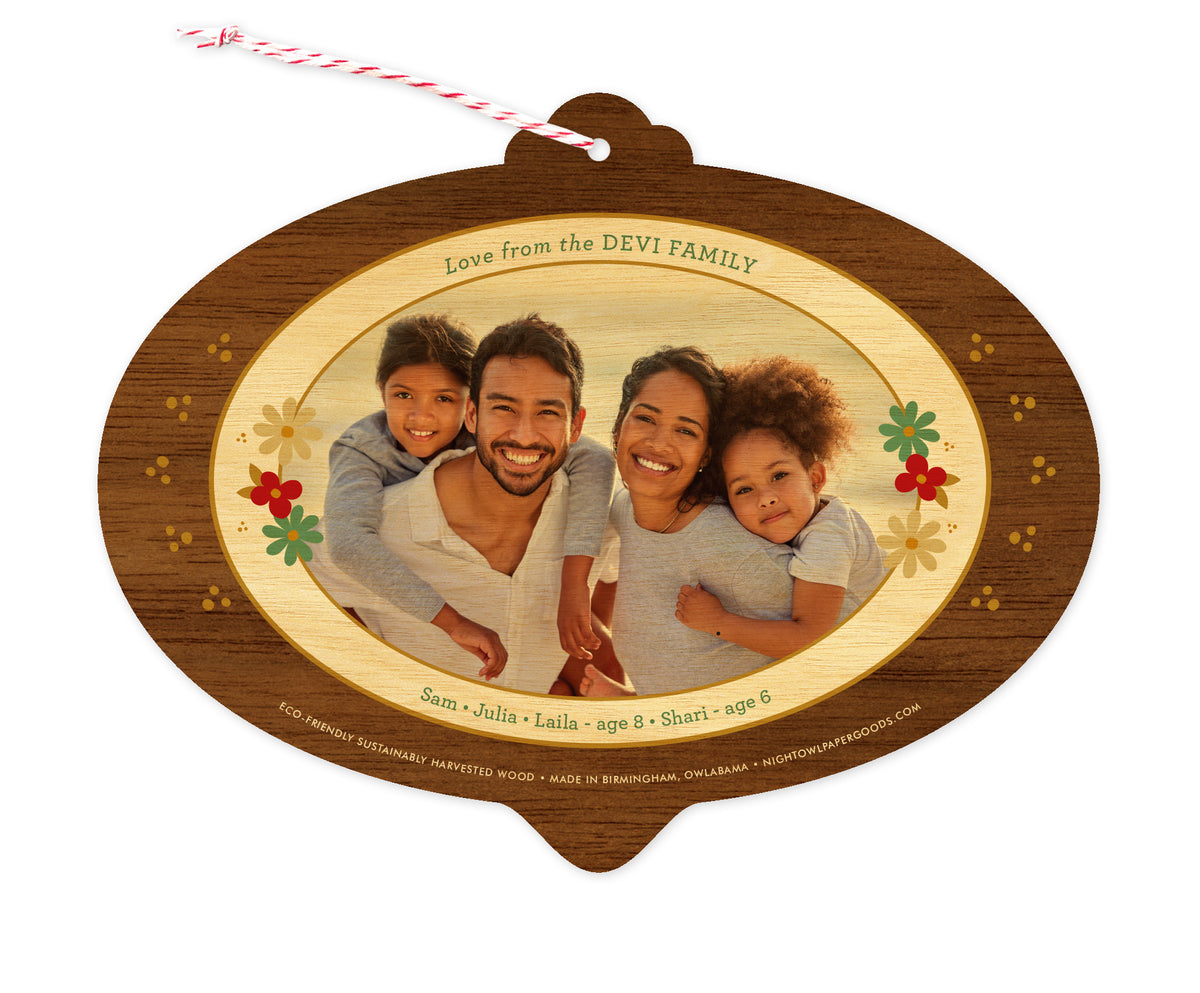Back of customizable bulb-shaped wood holiday ornament card with Photo + Text Back option showing a personal photo and message accented by several small flowers and a printed walnut wood grain border.