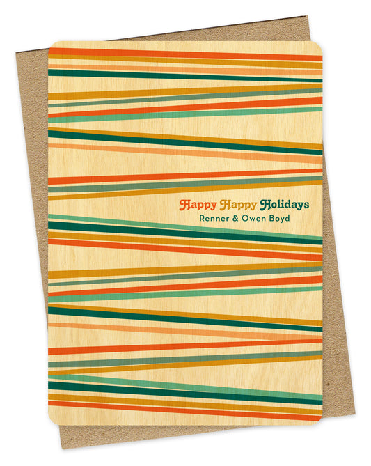 Customizable birch wood Christmas card with colorful stripes in bright shades of blue, orange and gold, "Happy Happy Holidays" text and a personal greeting. Shown with a kraft envelope.