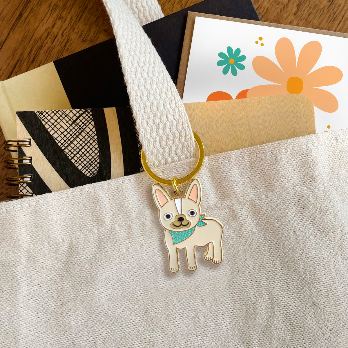 French Bulldog enamel keychain hanging from a tote bag handle