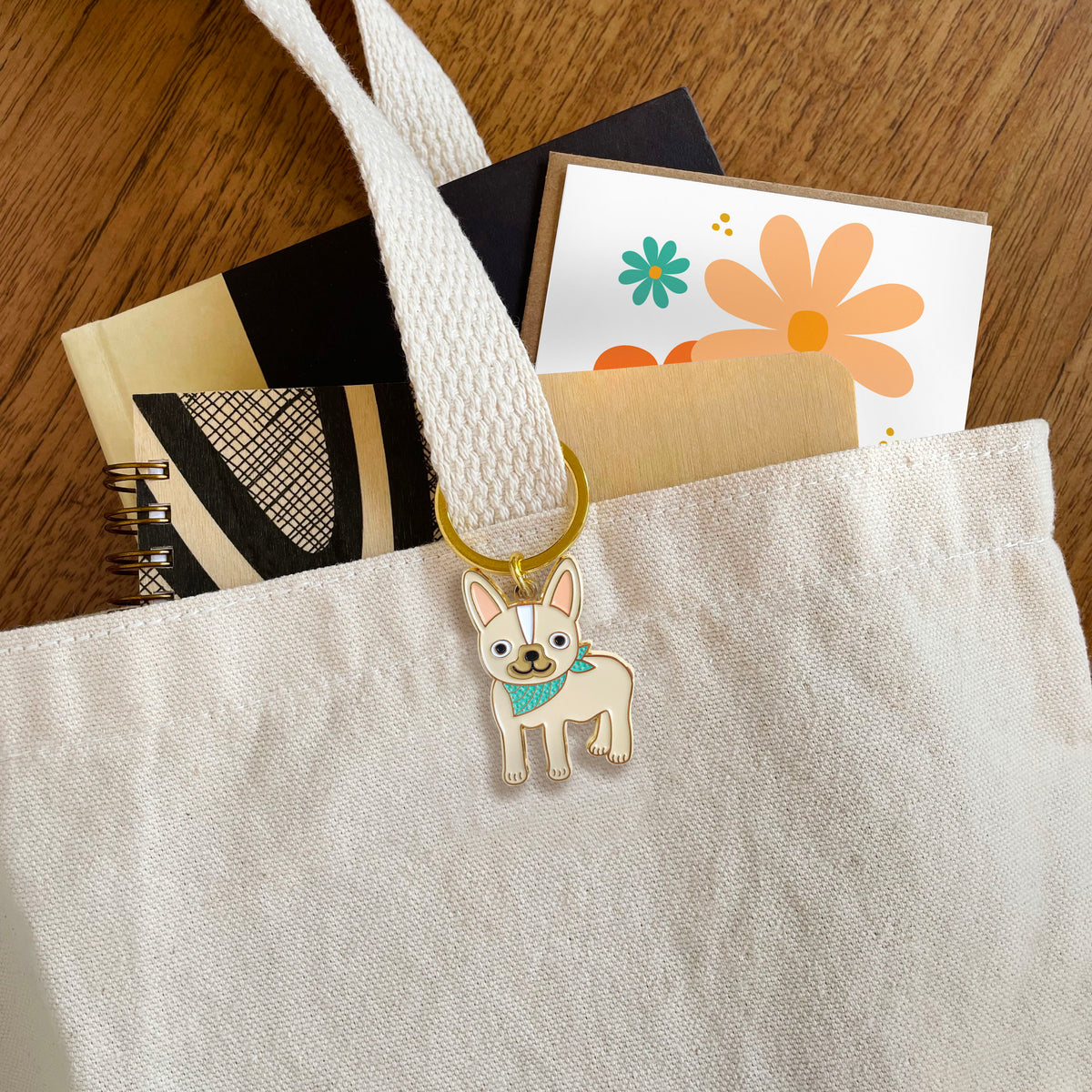 French Bulldog enamel keychain hanging from a tote bag handle