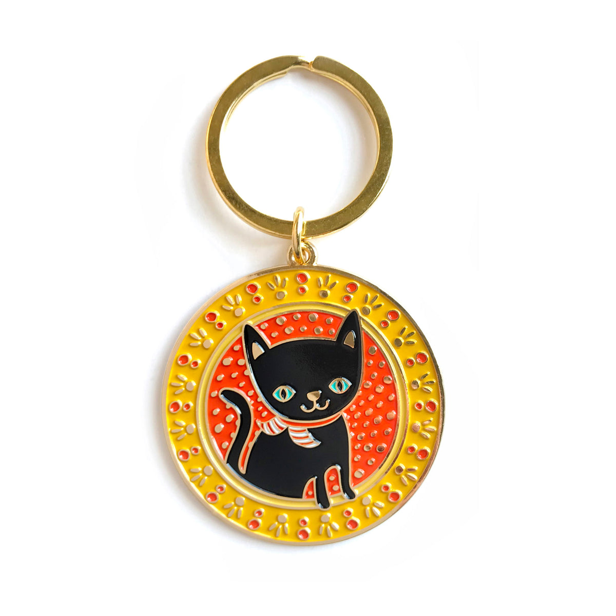 Gold metal black cat enamel keychain featuring a black cat with blue eyes on a round yellow and orange patterned background on a gold key ring