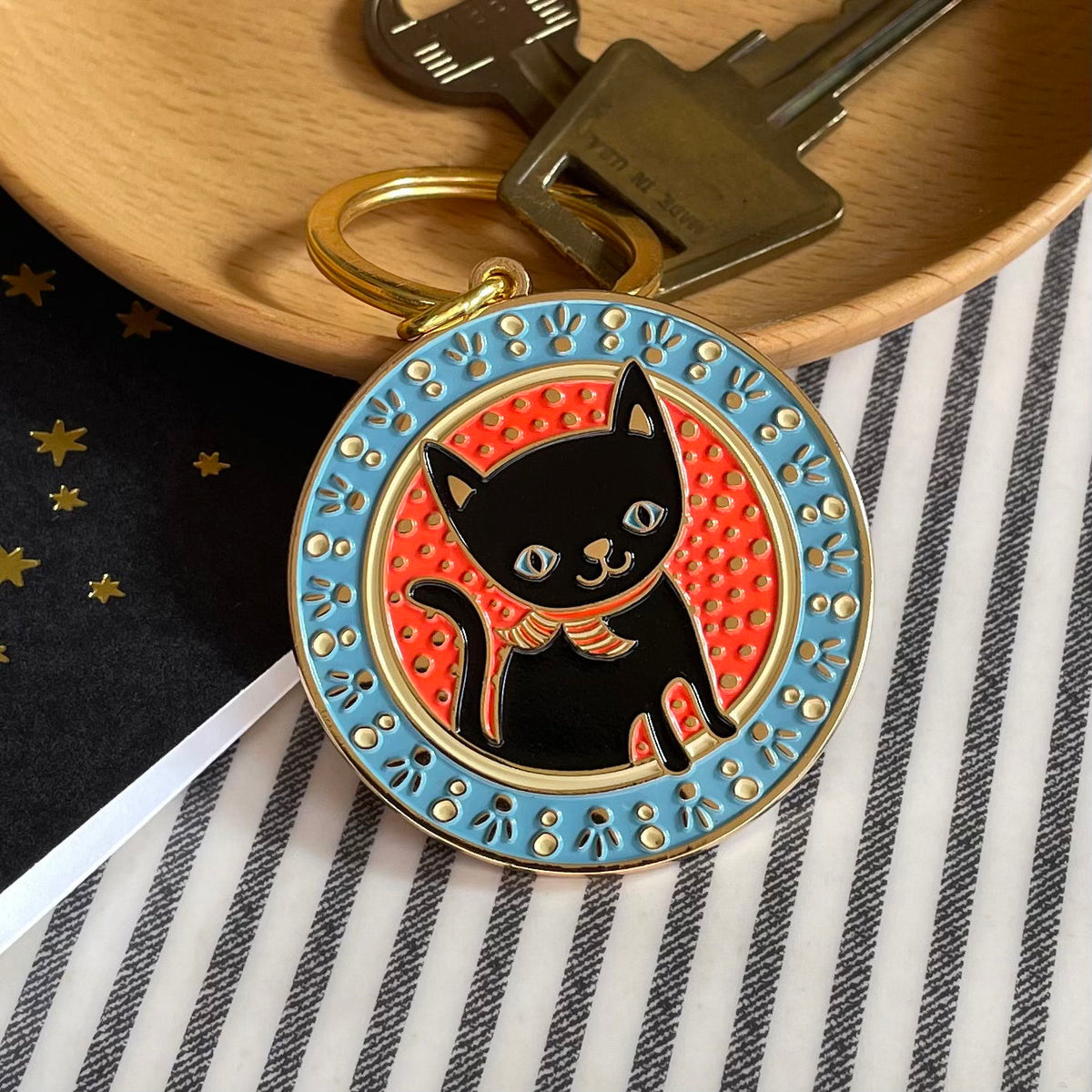 Black cat enamel keychain hanging from keys