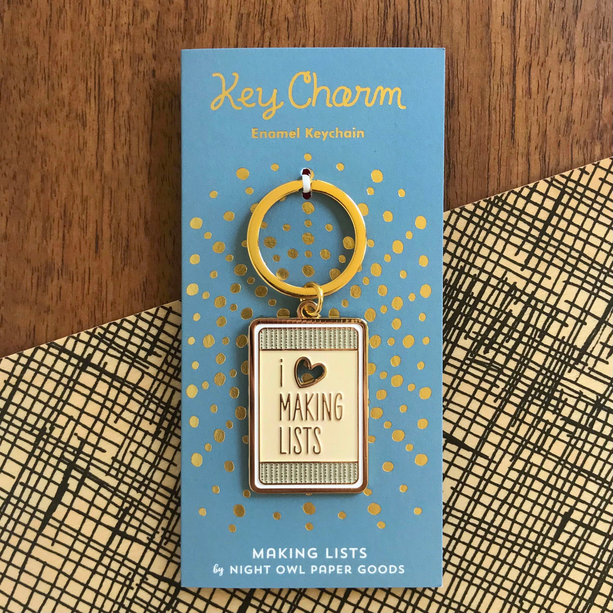Making Lists enamel keychain on gold foil stamped backer card. Soft blue backer card reads "Key Charm Enamel Keychain" at top and "Making Lists by Night Owl Paper Goods" at bottom.