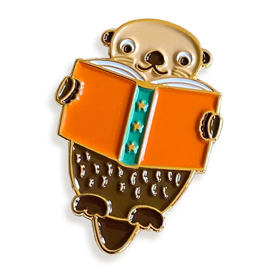 Enamel pin of an otter reading a book