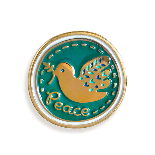 Circular shape teal enamel pin with a folksy gold dove holding an olive branch in its beak and gold 'Peace' text.