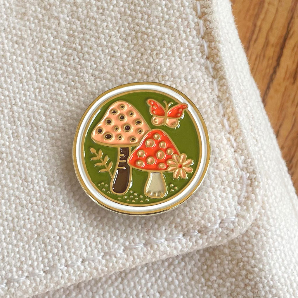 Mushrooms enamel pin displayed on canvas