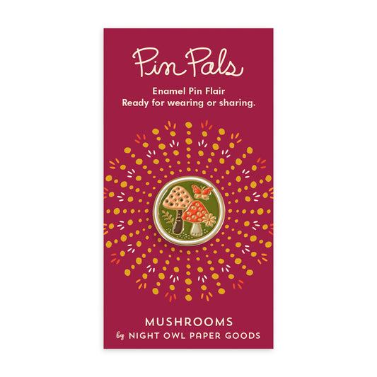 Round enamel pin with mushrooms and a butterfly on a green background, bordered with gold. Pin is on a maroon backer card that reads "Pin Pals - Enamel Pin Flair - Ready for wearing or sharing" at top and "MUSHROOMS by Night Owl Paper Goods" at bottom.