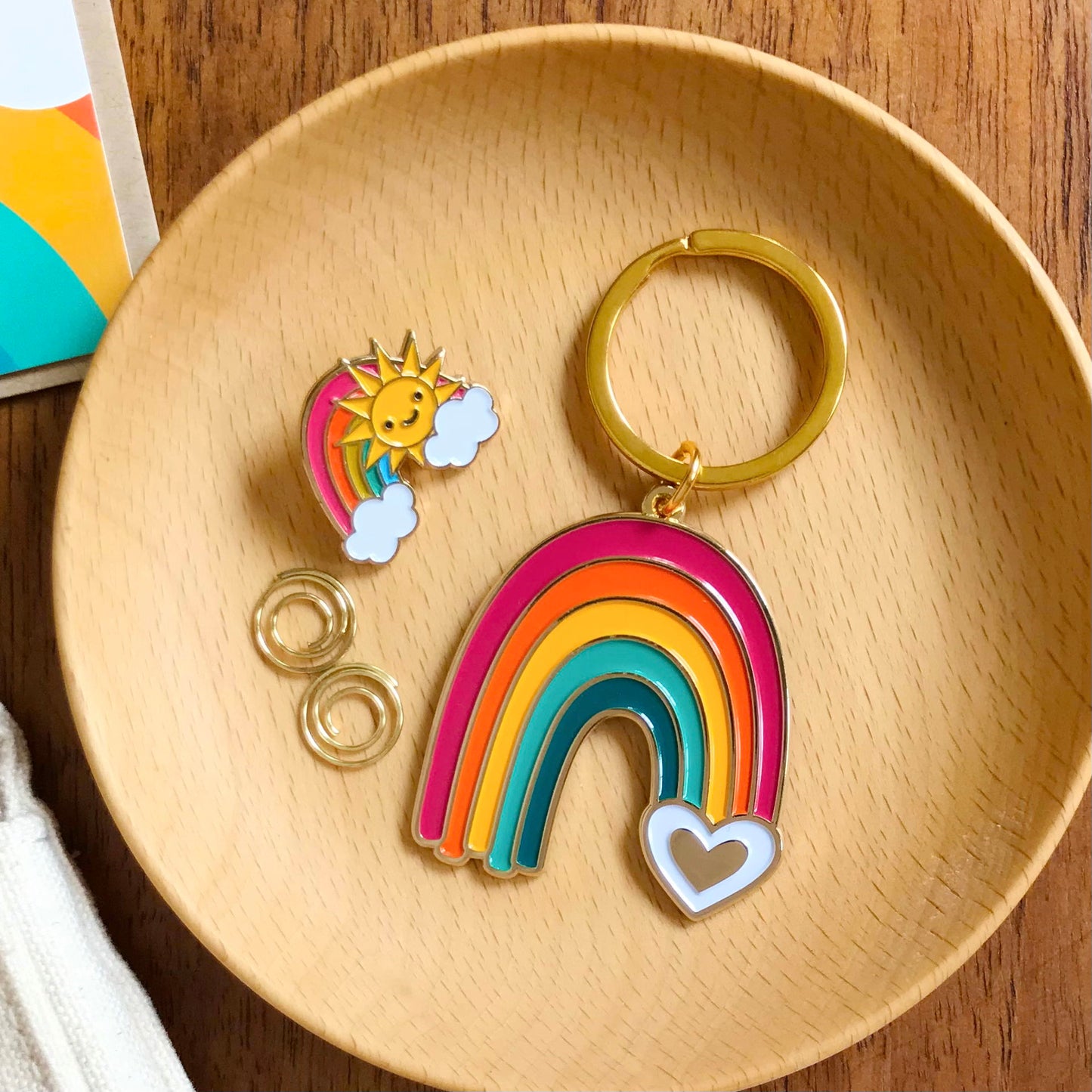 Rainbow enamel keychain displayed alongside the Rainbow enamel pin