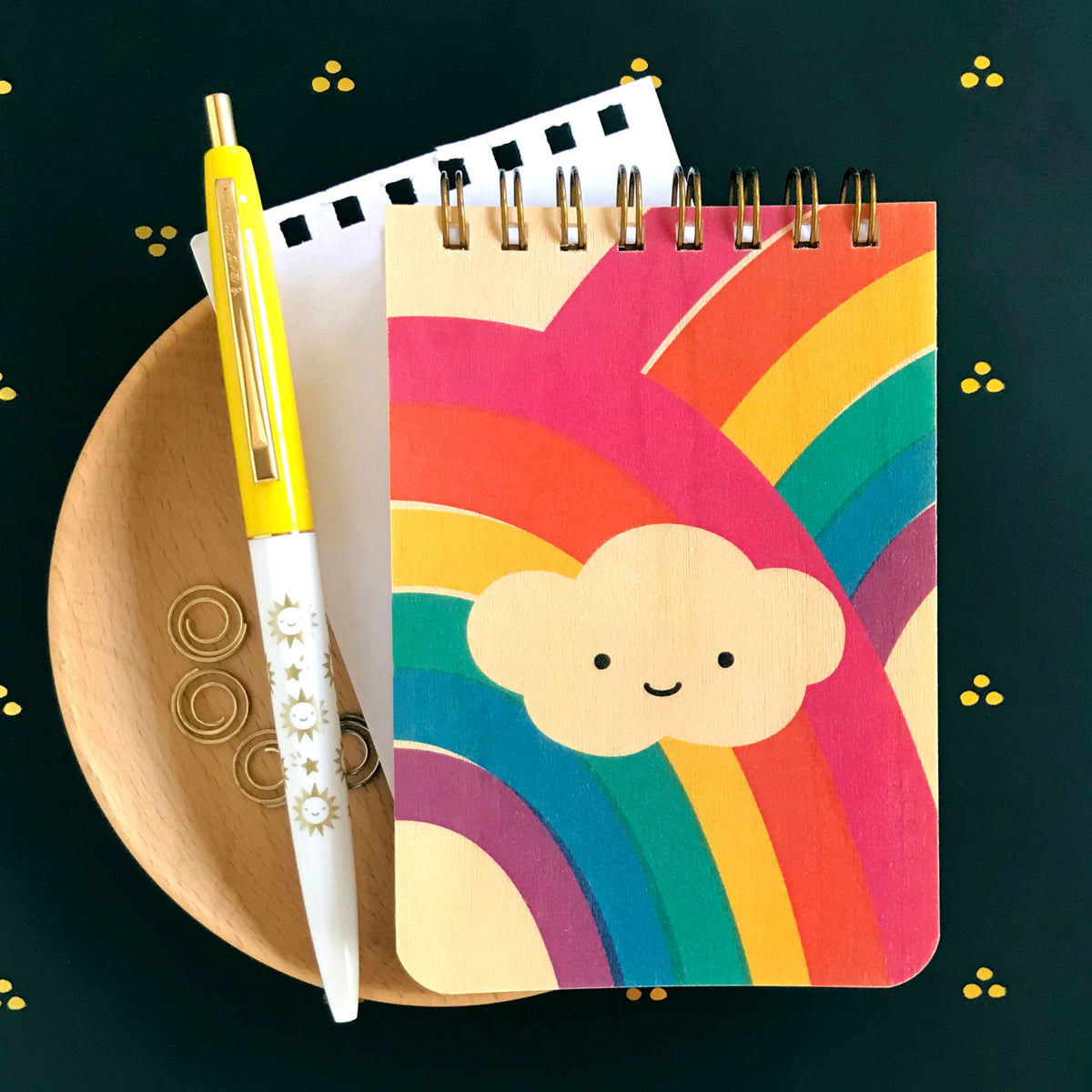 Click pen with yellow cap features fun illustrations of happy sun and shooting stars. Mini wood notepad with double rainbow and happy puffy cloud.
