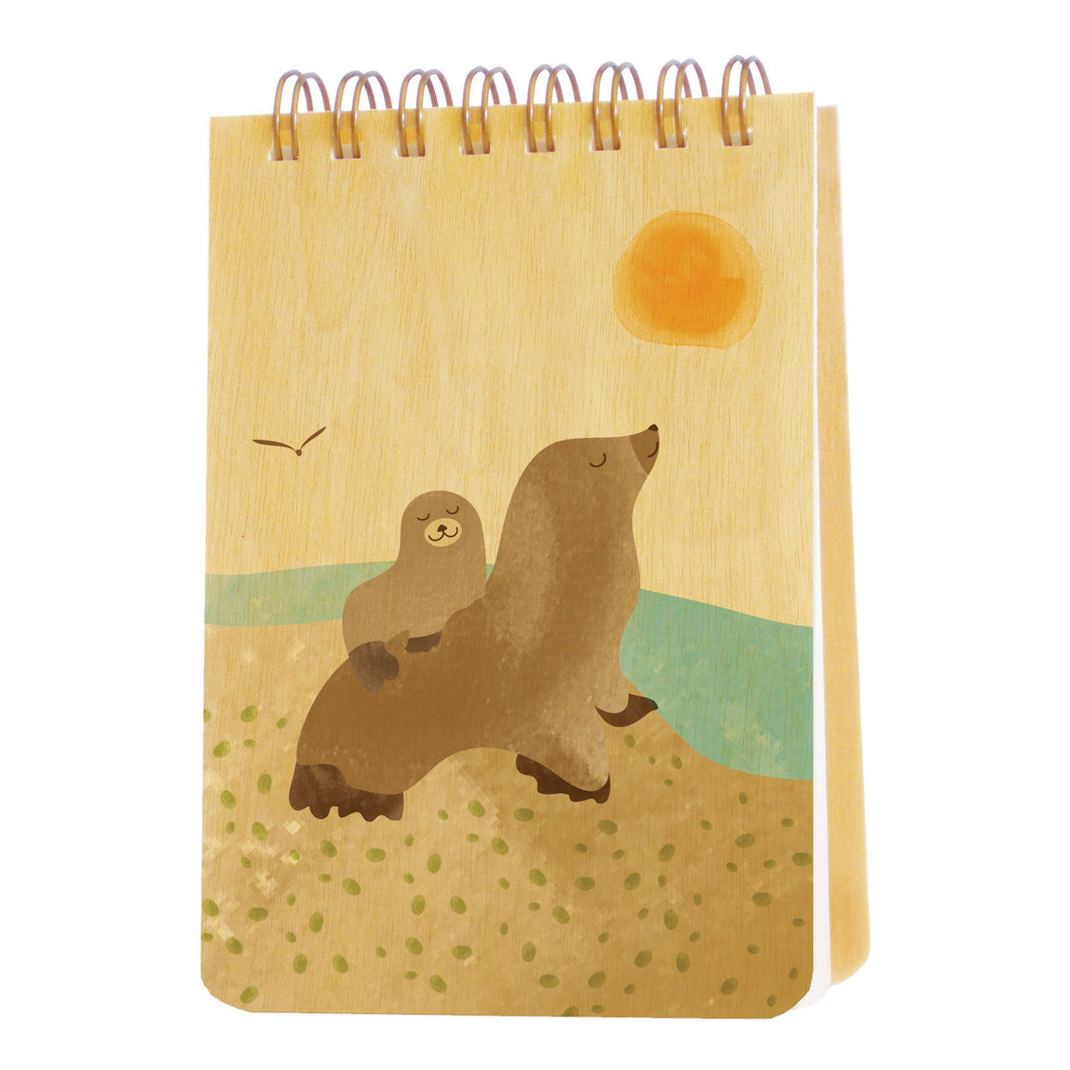 Spiral-bound wood mini notepad with birch wood covers featuring a family of two sea lions resting together on a sunny sandy shore with a seagull and golden sun overhead.