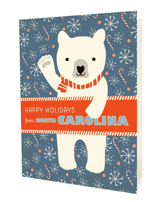 Polar North Carolina folded paper holiday card featuring a polar bear in a red striped scarf waving against a blue-gray background with snowflakes and candy canes and the greeting "Happy Holidays from North Carolina"