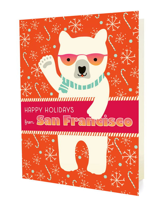 Polar San Francisco folded paper holiday card featuring a polar bear in pink sunglasses and a aqua scarf waving against a bright orange background with snowflakes and candy canes and the greeting "Happy Holidays from San Francisco"