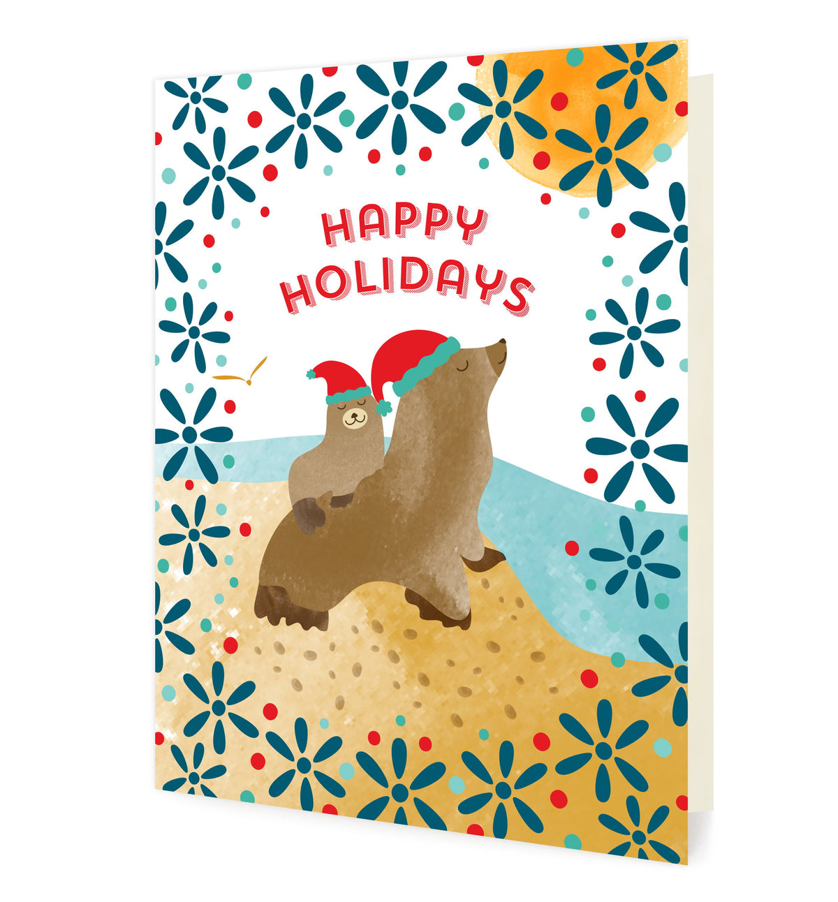 Sea Lions folded paper holiday card featuring two sea lions in red Santa hats on a sandy beach with aqua ocean waves, navy blue snowflake florals and a "Happy Holidays" greeting
