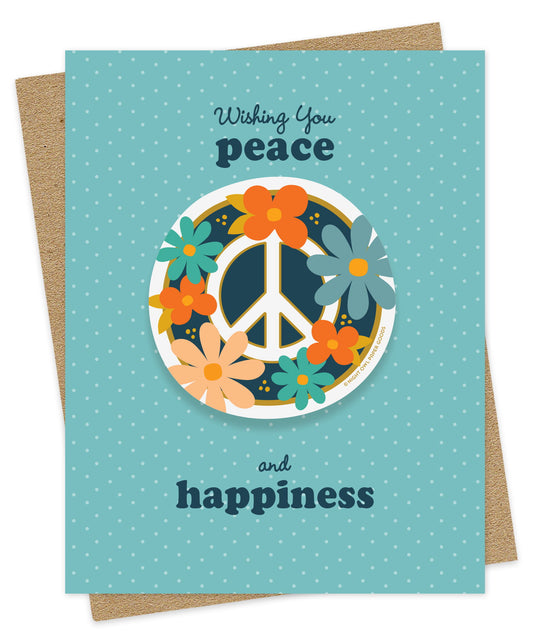 Floral Peace Sticker Holiday Card featuring a removable vinyl floral peace sign sticker with orange, teal and peach flowers on a soft teal dotted background with the greeting "Wishing You Peace and Happiness." Shown with a kraft envelope.