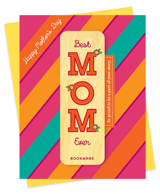 Folded Mother's Day card with a bold diagonal stripe design in pink, orange and teal, Happy Mother's Day text and a removable birch wood bookmark spelling out Best MOM Ever with floral accents and the message So Proud to Be a Part of Your Story. Pictured with a yellow envelope.