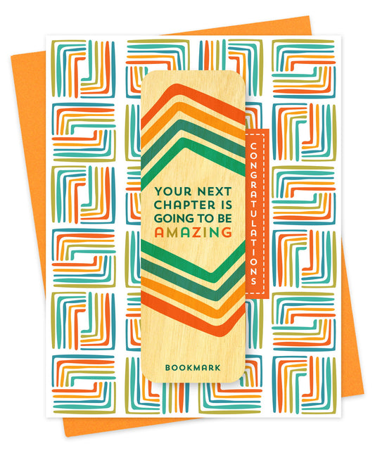 Folded congratulations card with a bold geometric pattern in orange, teal, yellow and green, Congratulations text and a removable birch wood bookmark featuring a retro chevron design and the message Your Next Chapter Is Going to Be Amazing. Pictured with an orange envelope.