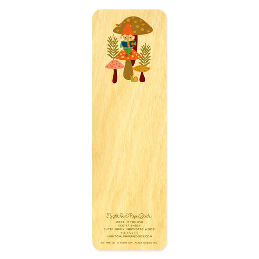 Back side of wooden bookmark with an illustration of a gnome sitting on a mushroom reading a book. At the bottom: Night Owl Paper Goods script logo with text reading "Made in the USA - Eco-Friendly Sustainably Harvested Wood - Visit us at nightowlpapergoods.mom."
