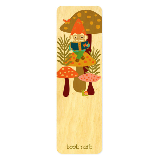 Wooden bookmark with an illustration of a gnome sitting on a mushroom reading. Text at bottom reads "bookmark." 