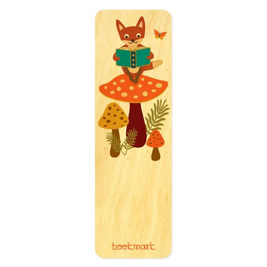 Birch wood bookmark with fox sitting on a big mushroom reading a book. Text at bottom reads "bookmark." 