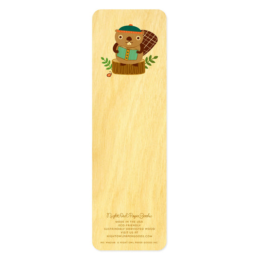Back of birch wood bookmark with a beaver wearing a stocking cap sitting on a tree stump and reading a book. At the bottom: Night Owl Paper Goods script logo with text reading "Made in the USA - Eco-Friendly Sustainably Harvested Wood - Visit us at nightowlpapergoods.mom."