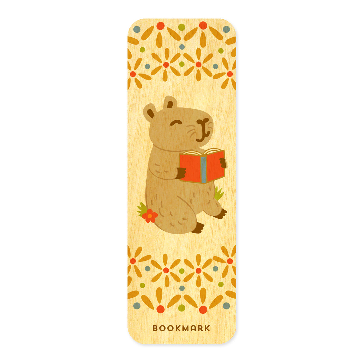 Front of Capybara birch wood mini bookmark featuring a cute capybara holding an open red book, surrounded by decorative floral patterns in orange, yellow, green and blue. Text at bottom reads "BOOKMARK."